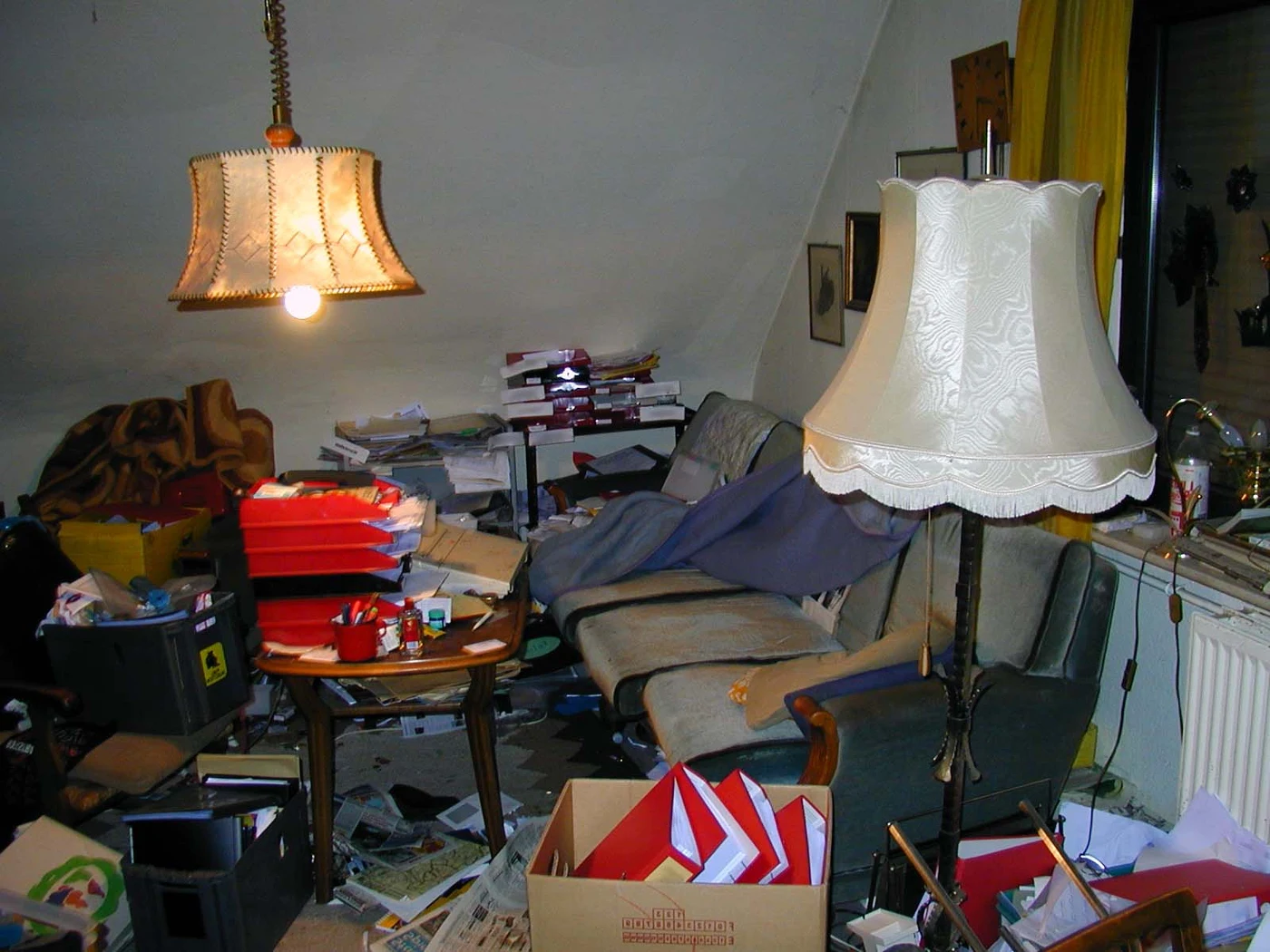 A cluttered room packed with boxes and furniture before a cleanout
